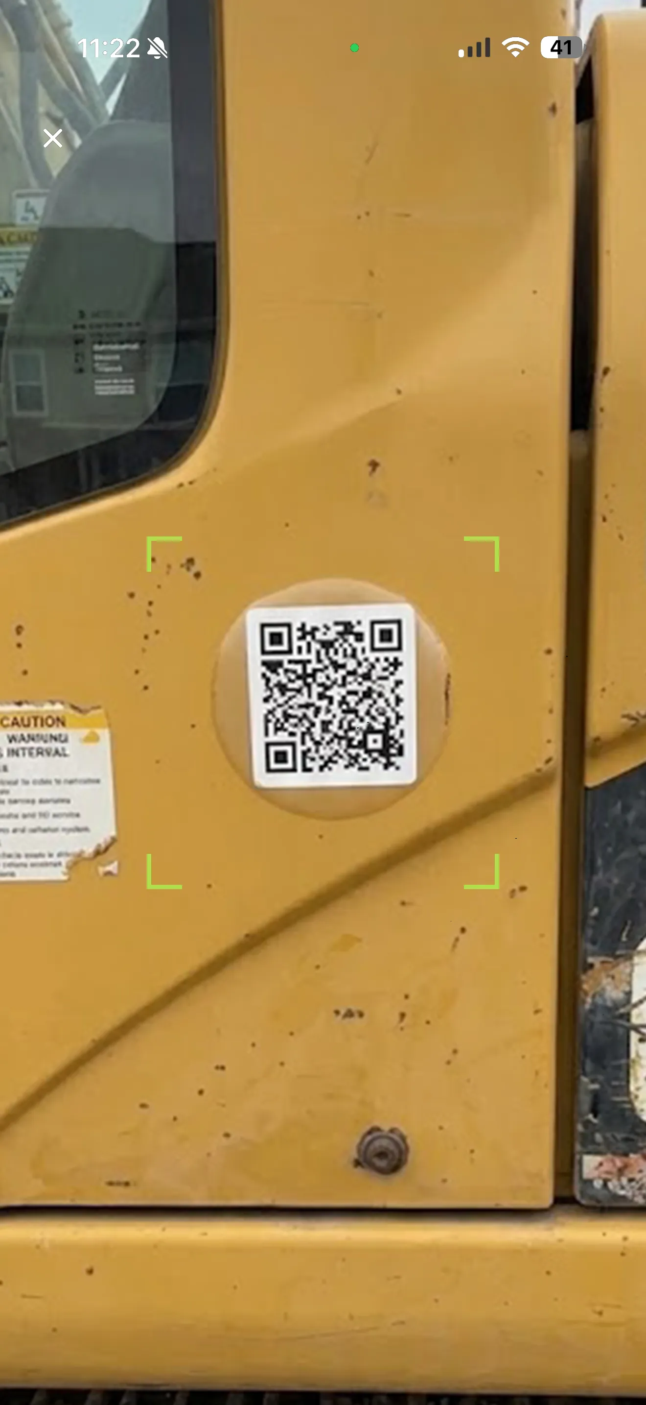 Fleet Mobile scanning a QR code stuck on a piece of heavy equipment in the yard to start a field check-in